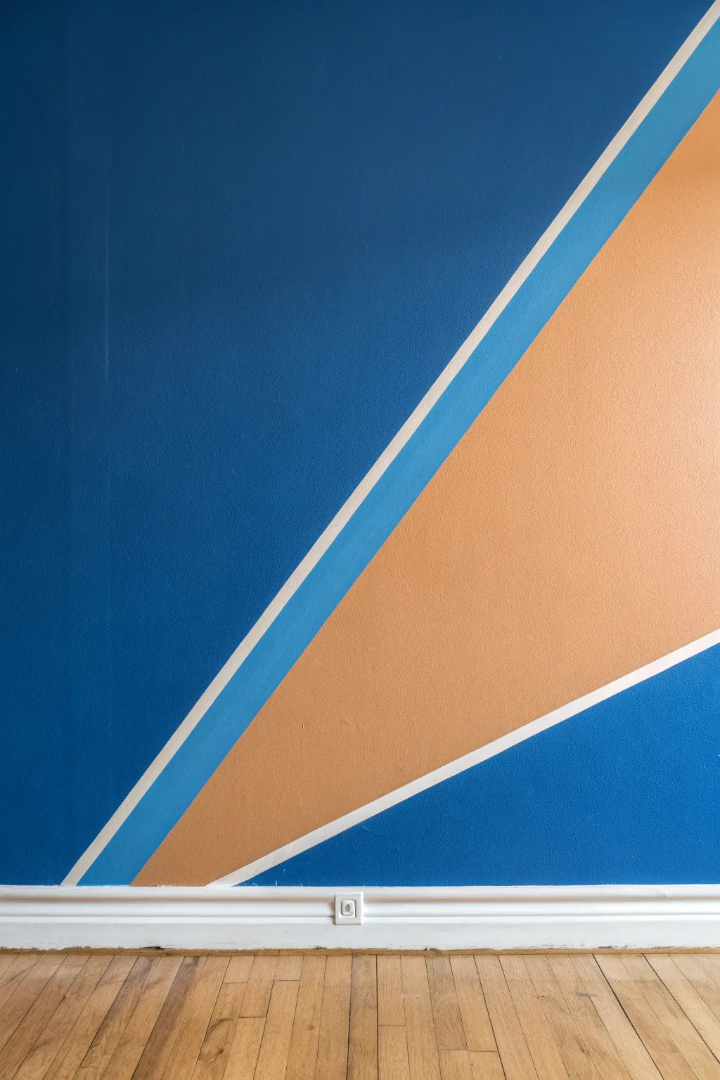 Bold diagonal color split wall with crisp taped edge for an easy Scandinavian-boho DIY statement.