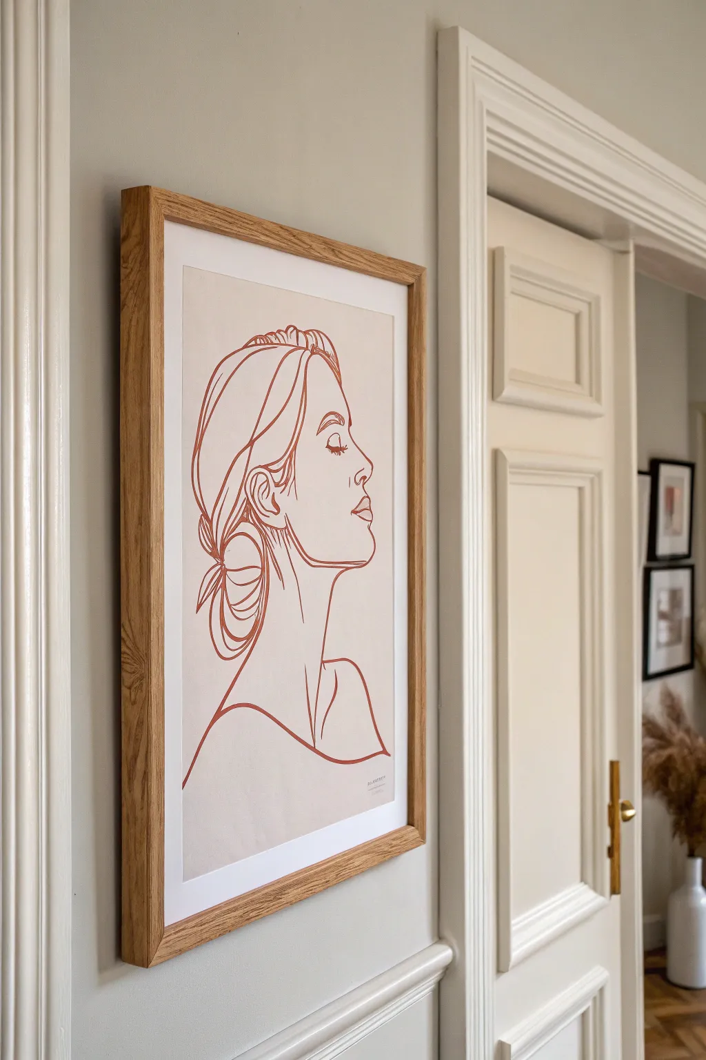 Minimal line-art portrait in a slim oak frame for understated, intentional wall art.