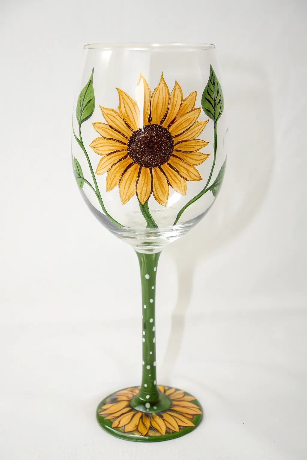 A bold sunflower wine glass where the painted bloom sits on the bowl and the stem becomes the stalk.