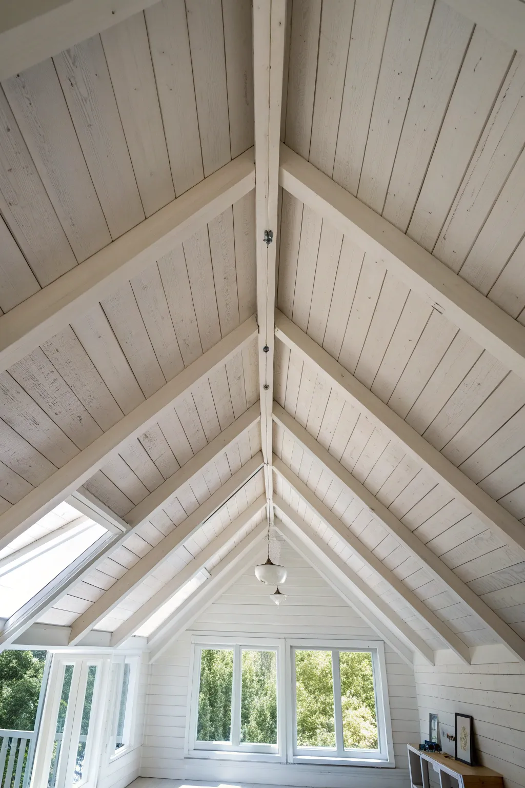Painted beams matching the ceiling create a calm, seamless attic look with soft shadow contrast.