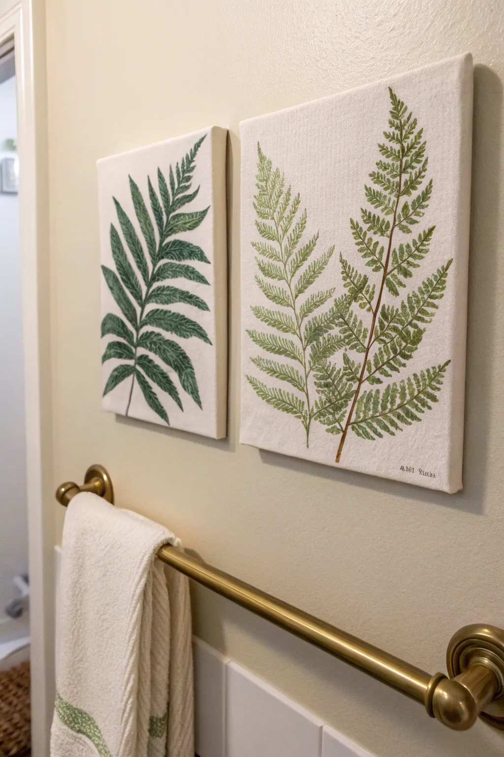Two minimalist fern-leaf canvases in soft green bring fresh, spa-like brightness to the bath.