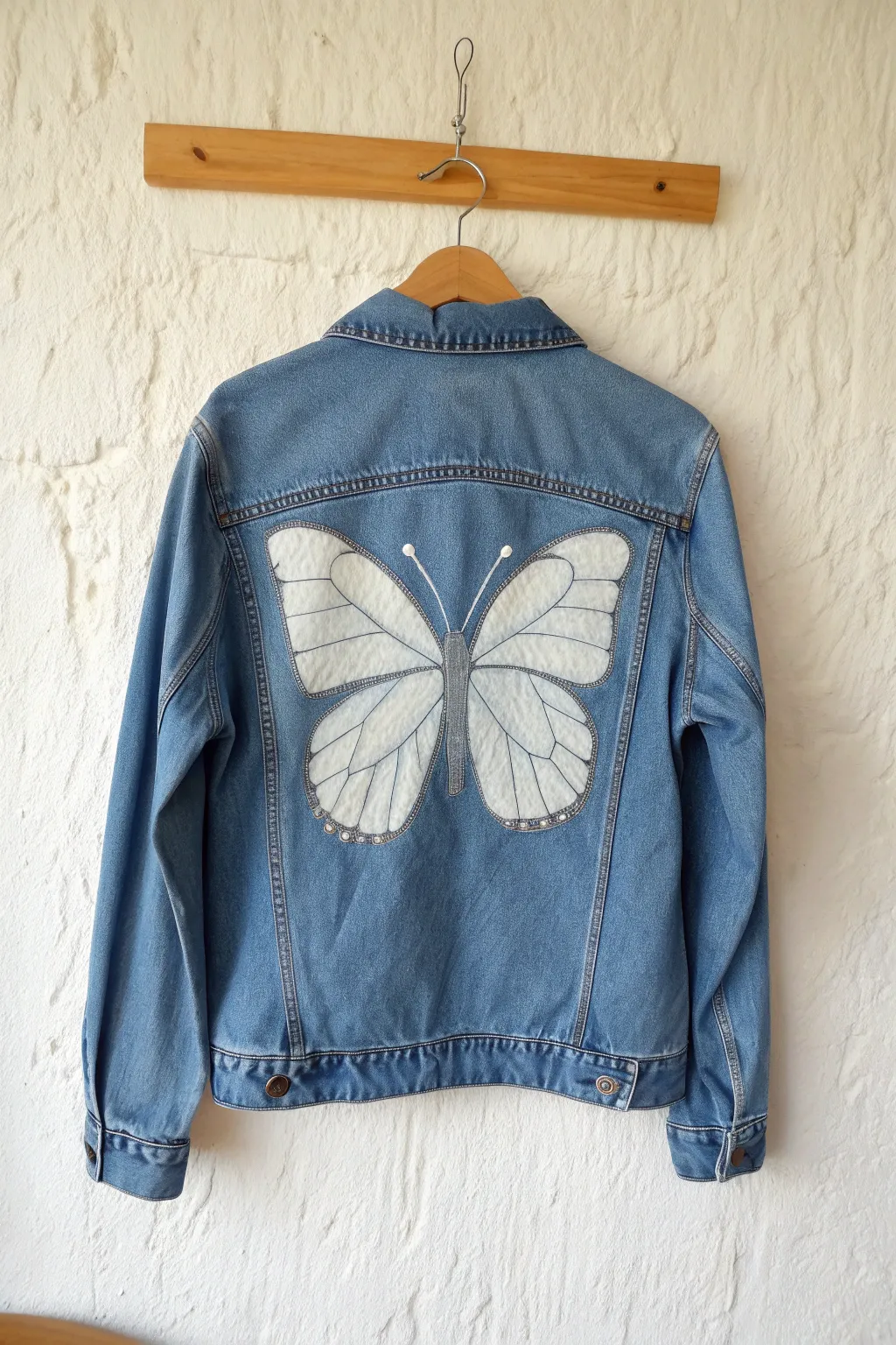 Centered butterfly on a denim jacket, simple shading and clean symmetry for an easy painting idea