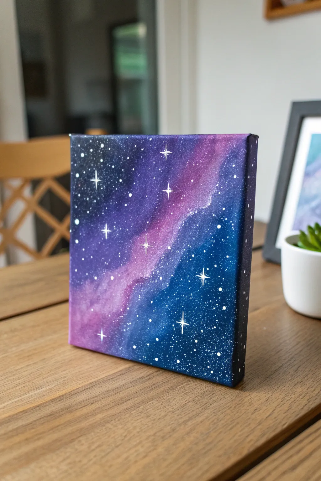 Mini galaxy canvas in deep blues and purples with crisp white splatter stars, simple and dreamy