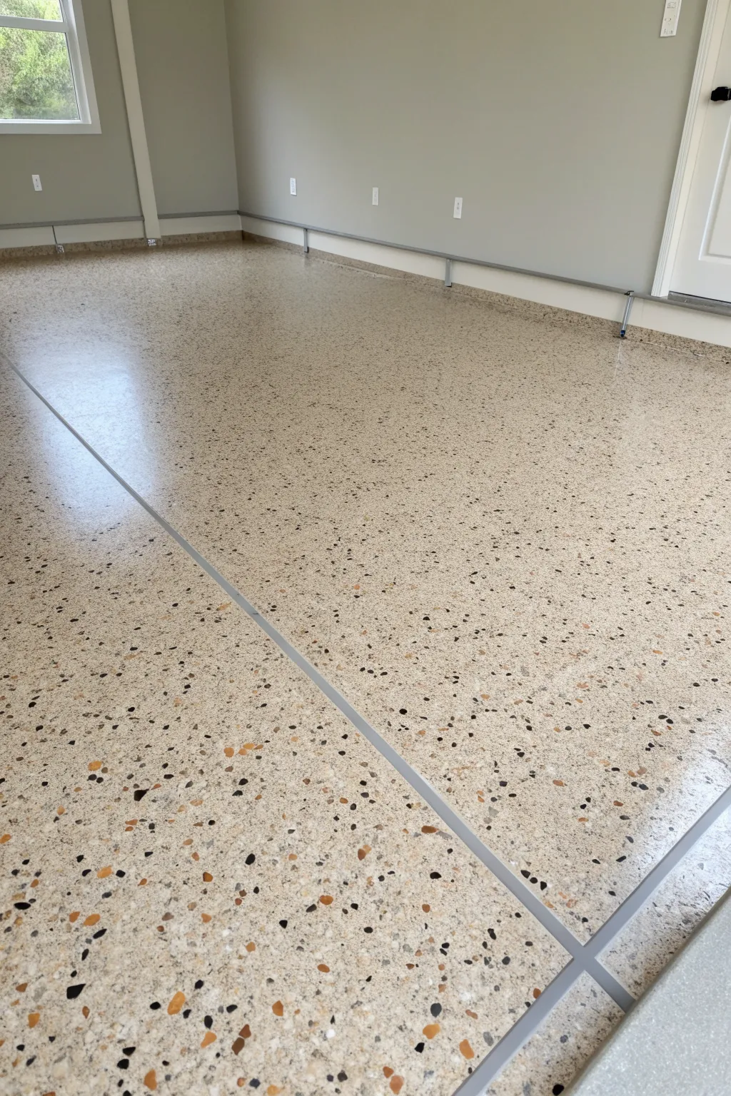 Terrazzo-style flake epoxy in calming neutrals, crisp edges and clean contrast for modern spaces.