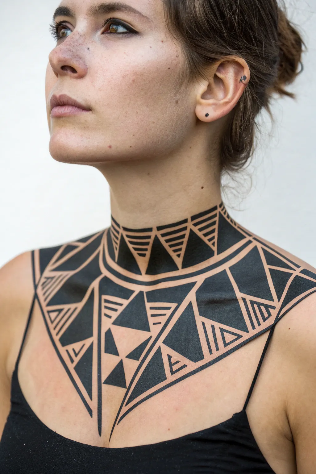 Symmetrical geometric body paint across collarbones, minimalist lines with a soft boho touch.