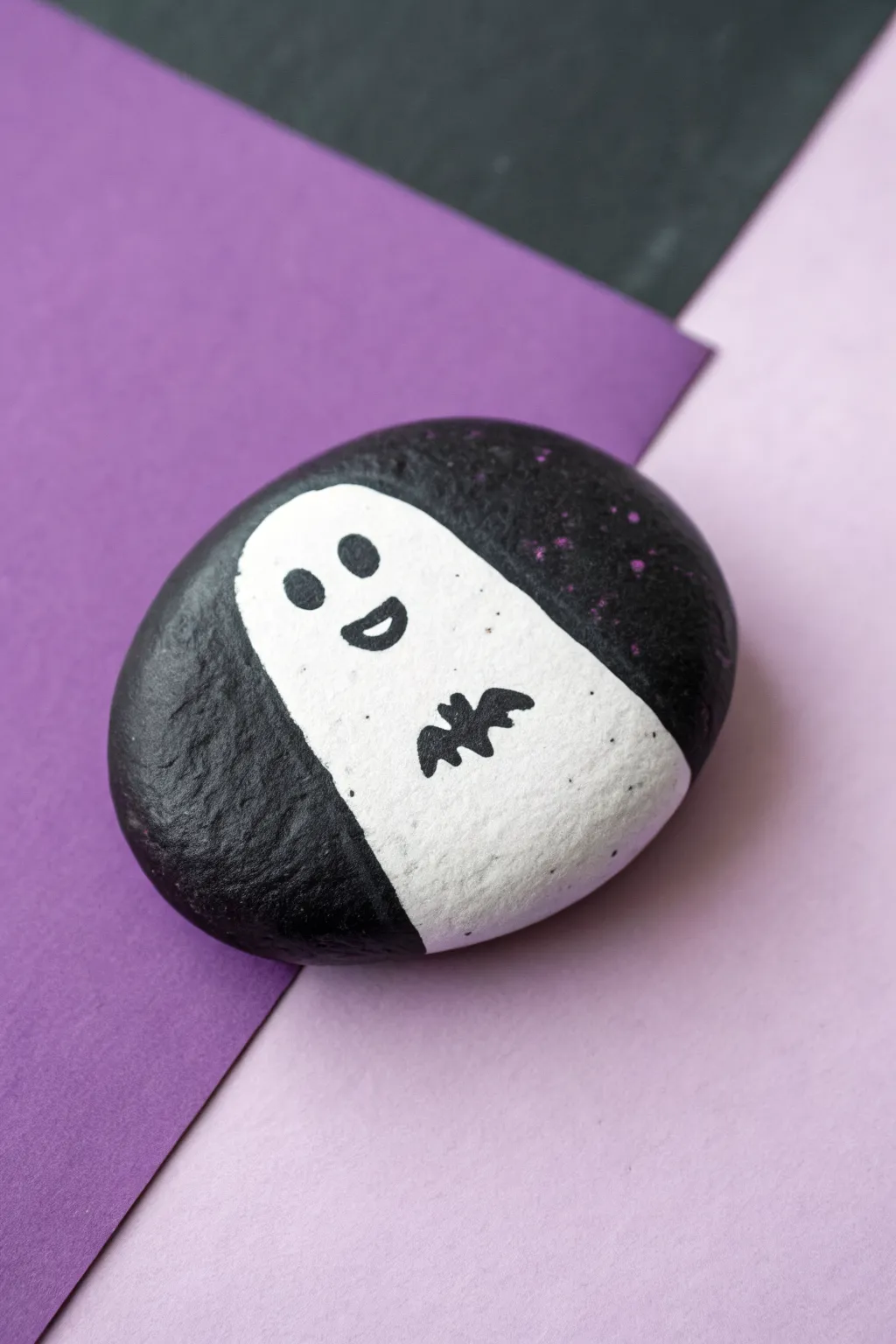 Paint a bold color-block rock with a tiny floating ghost for chic minimalist Halloween decor.