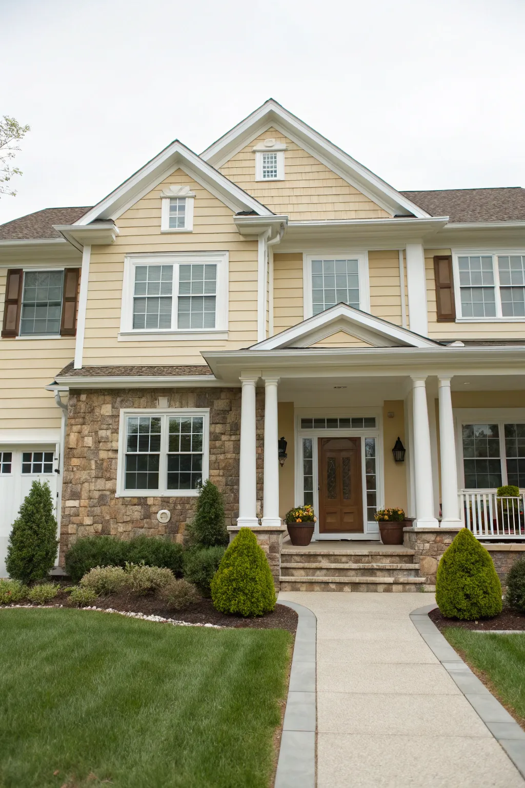 Warm beige siding with stone accents and crisp white trim for timeless, cozy curb appeal.
