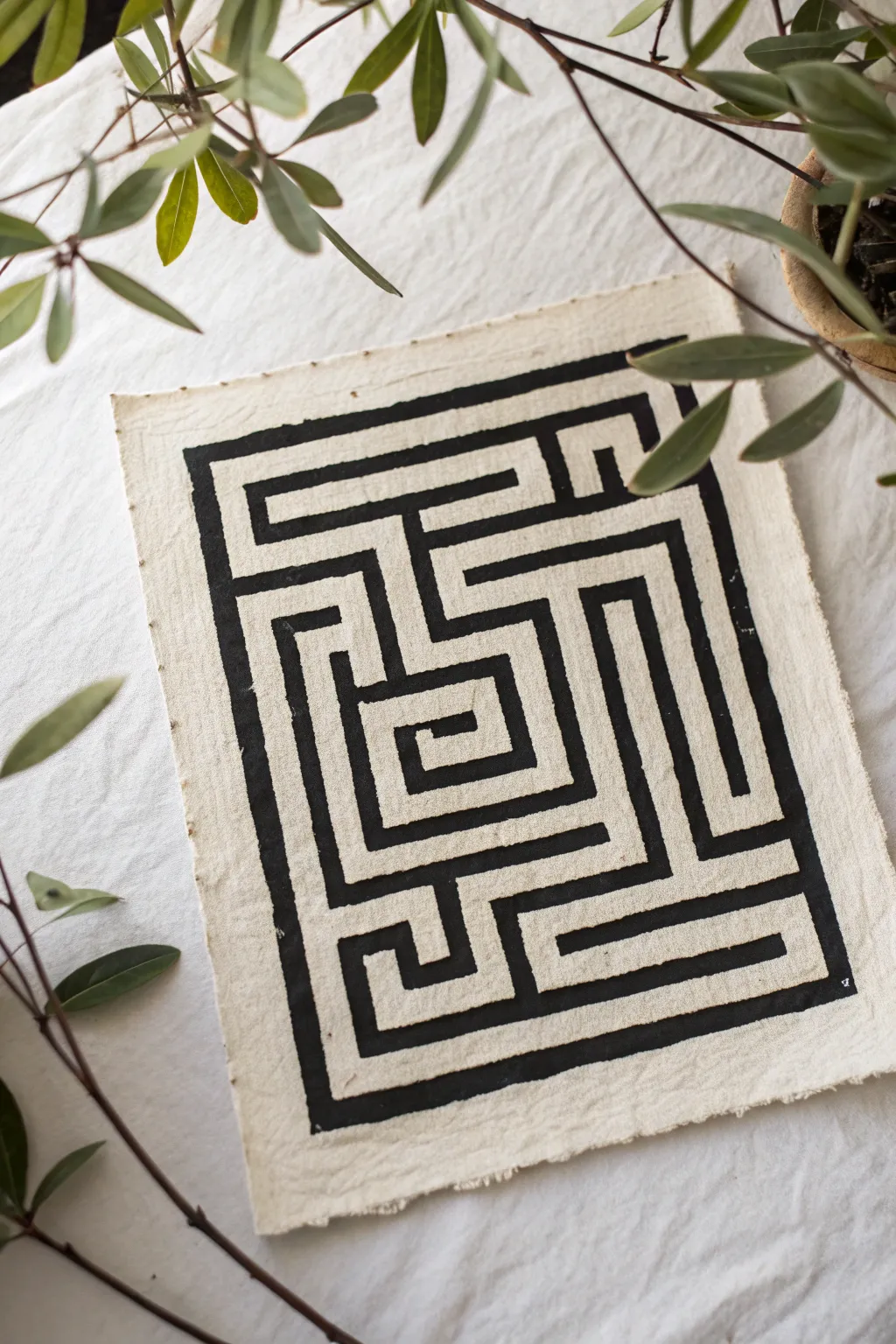Bold black ink maze with thick outer walls and fine inner paths, minimalist and graphic.