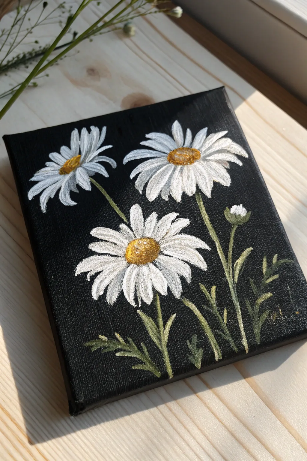 Mini black canvas with crisp white daisies and textured centers for bold, minimal contrast