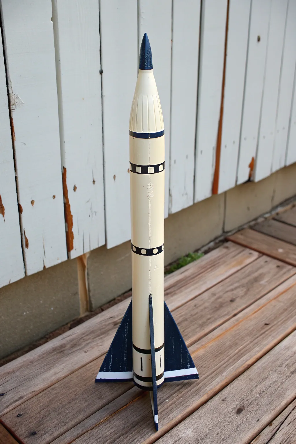 Bold fin color blocking: cream body with charcoal fins for a crisp, modern model rocket look.