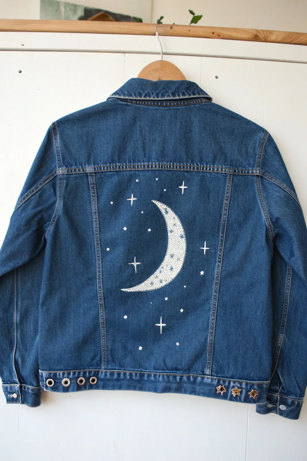 Moon and stars night-sky painted jean jacket back panel with simple boho sparkle and bold contrast