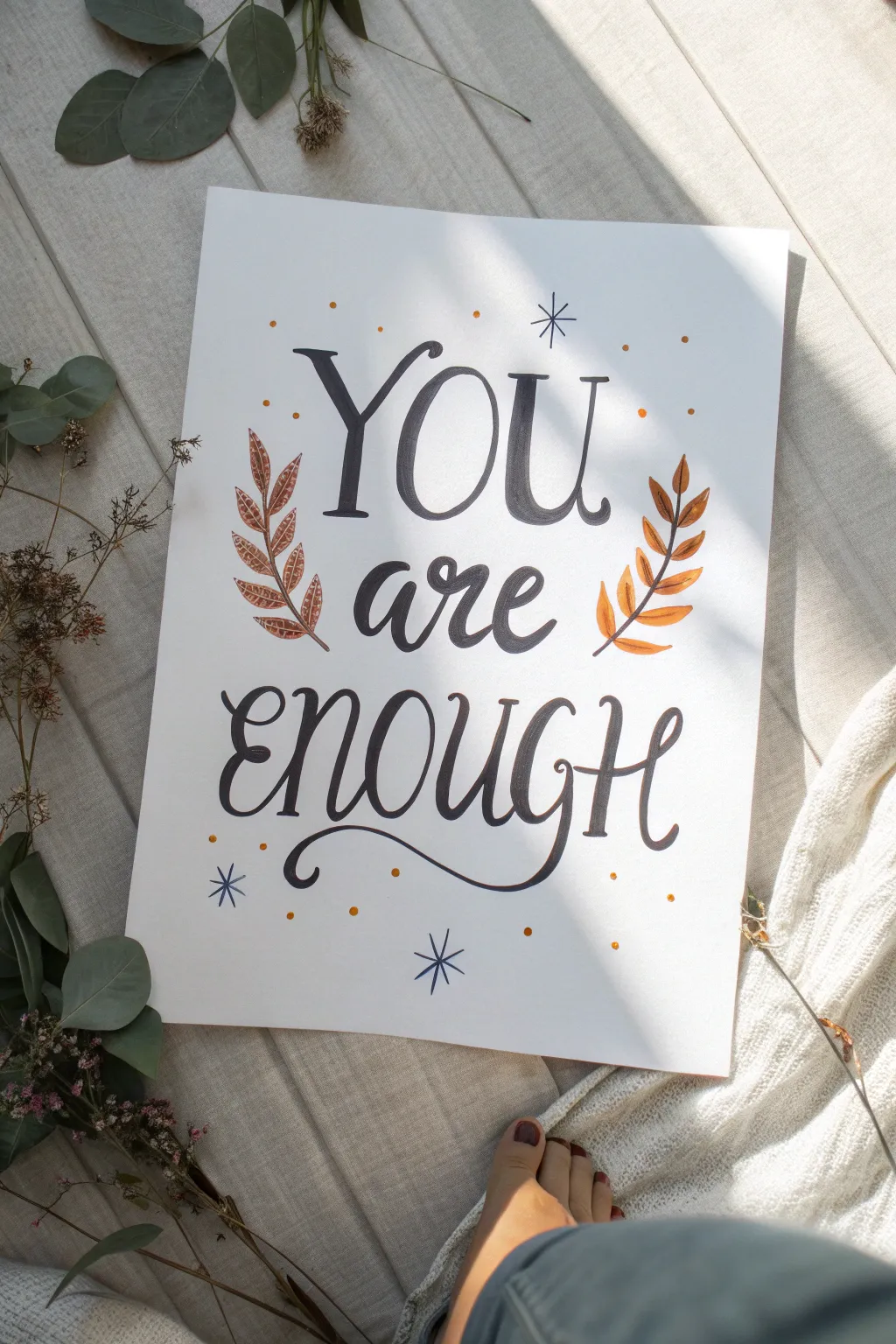 Hand-lettered uplifting quote with a minimalist leafy border for a calm, positive drawing idea.