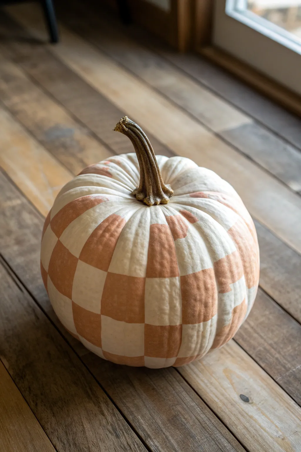 Cozy gingham-painted pumpkin on rustic wood, minimalist Scandinavian style with warm contrast