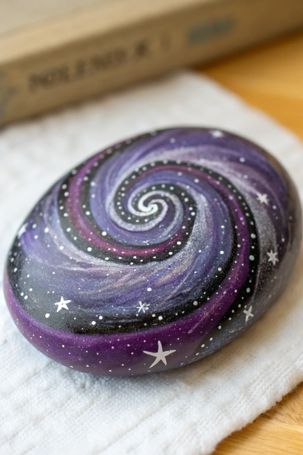 Purple galaxy swirl rock with star speckles, minimalist close-up with dreamy boho calm.