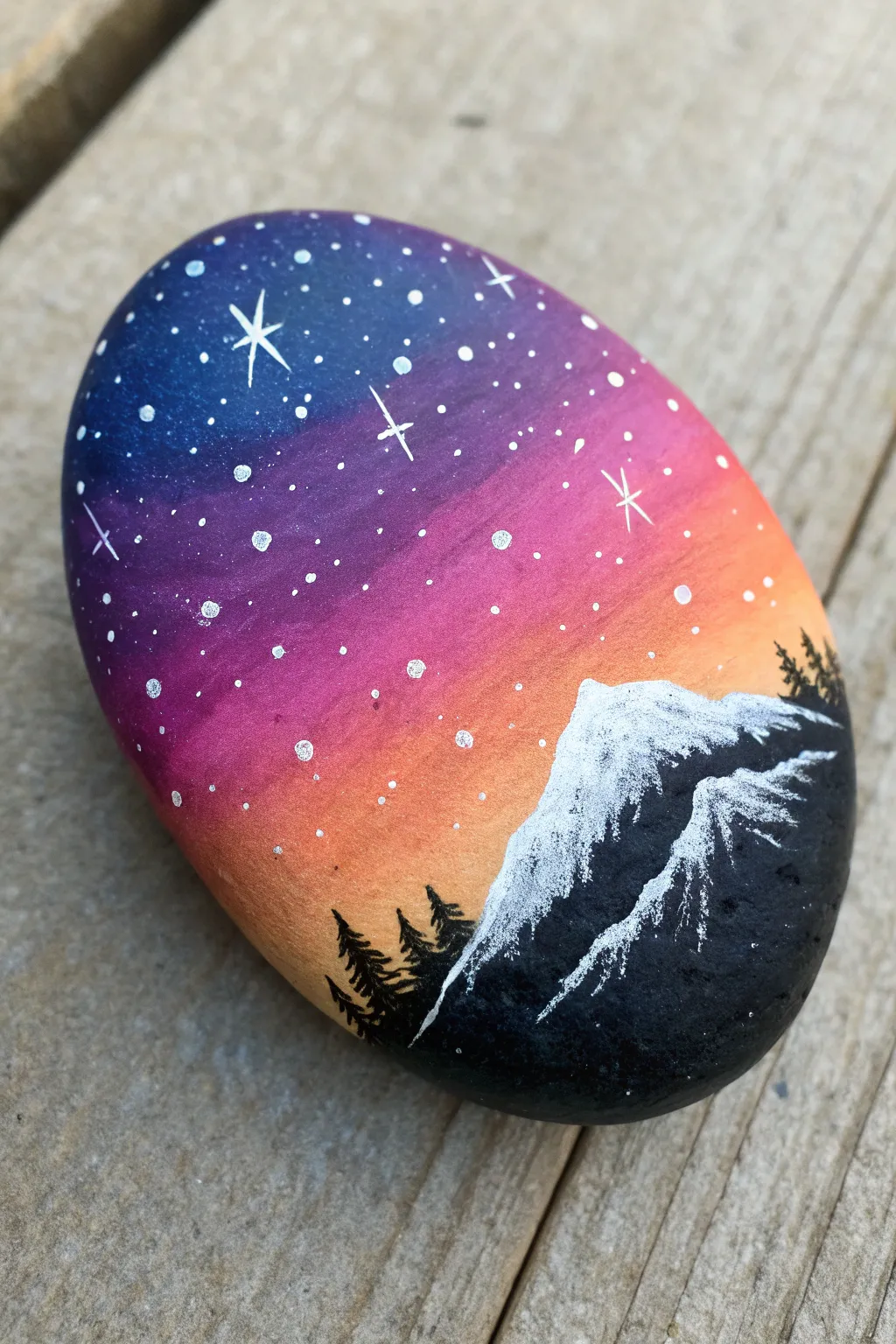 Cosmic sunset rock with nebula hues, starry speckles, and a bold mountain silhouette.