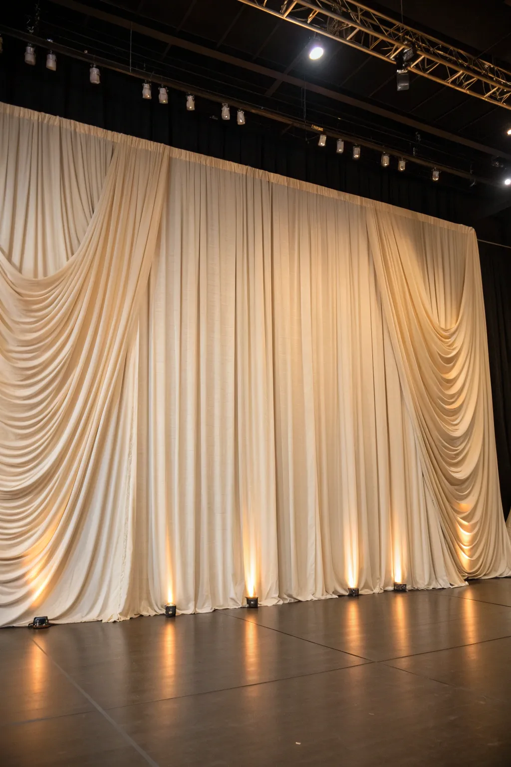 Classic swags and pleats in warm light, a timeless stage backdrop with elegant texture.