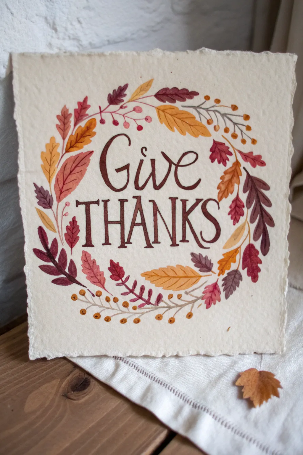 Warm autumn wreath artwork with bold Give Thanks lettering, minimalist boho style for paint night.