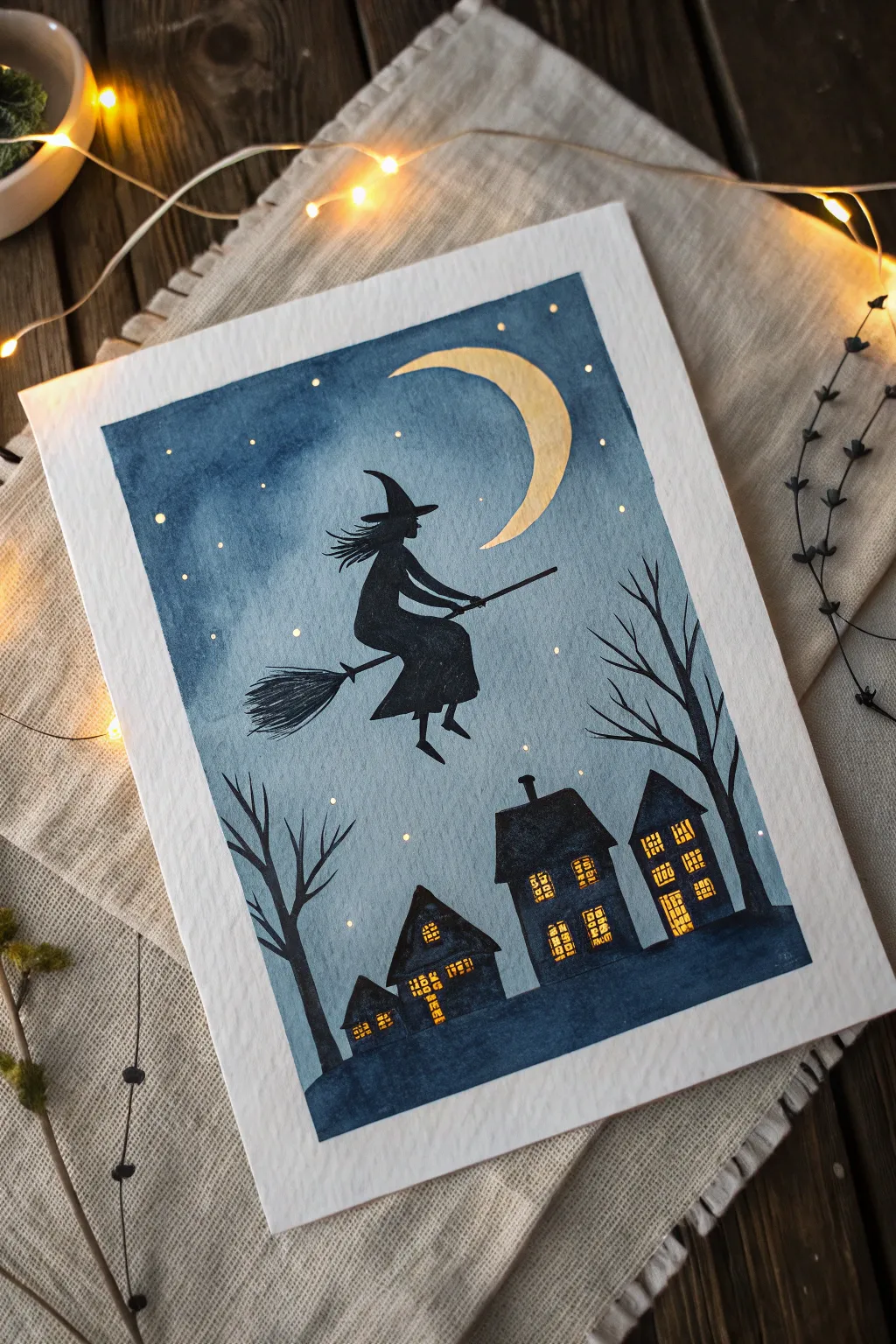 Minimalist witch on a broom soaring above glowing rooftops under a cool indigo night sky.