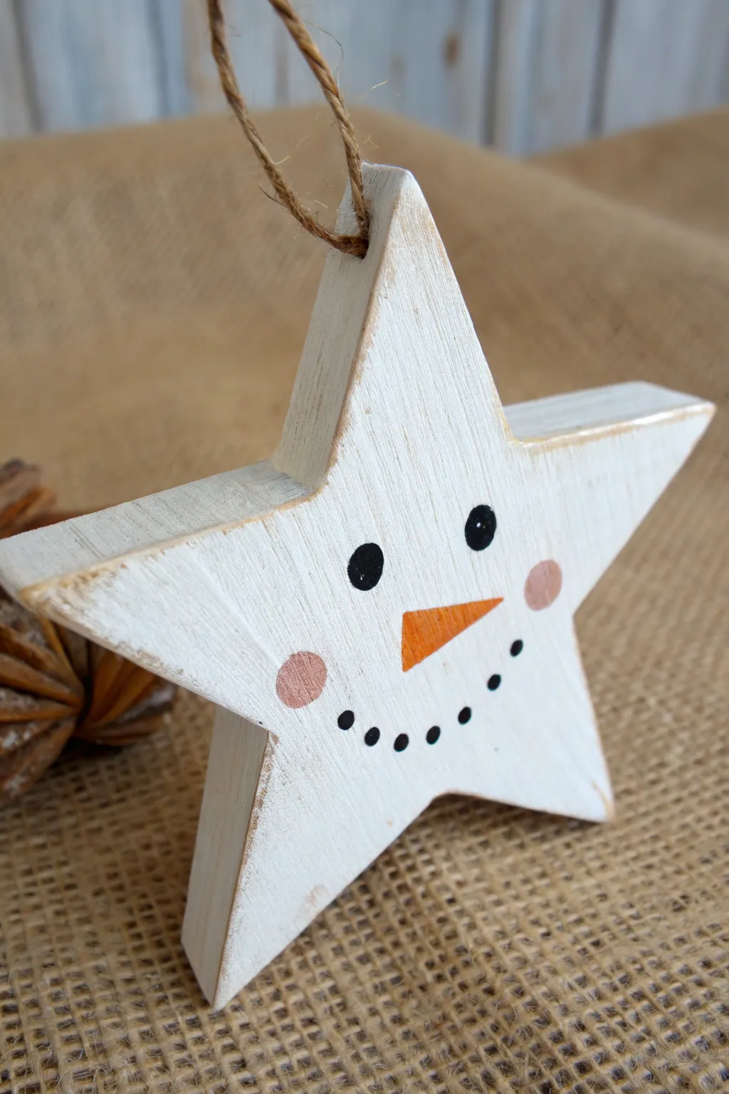 Snowman face on a wooden star, minimalist winter craft with cozy Scandinavian charm