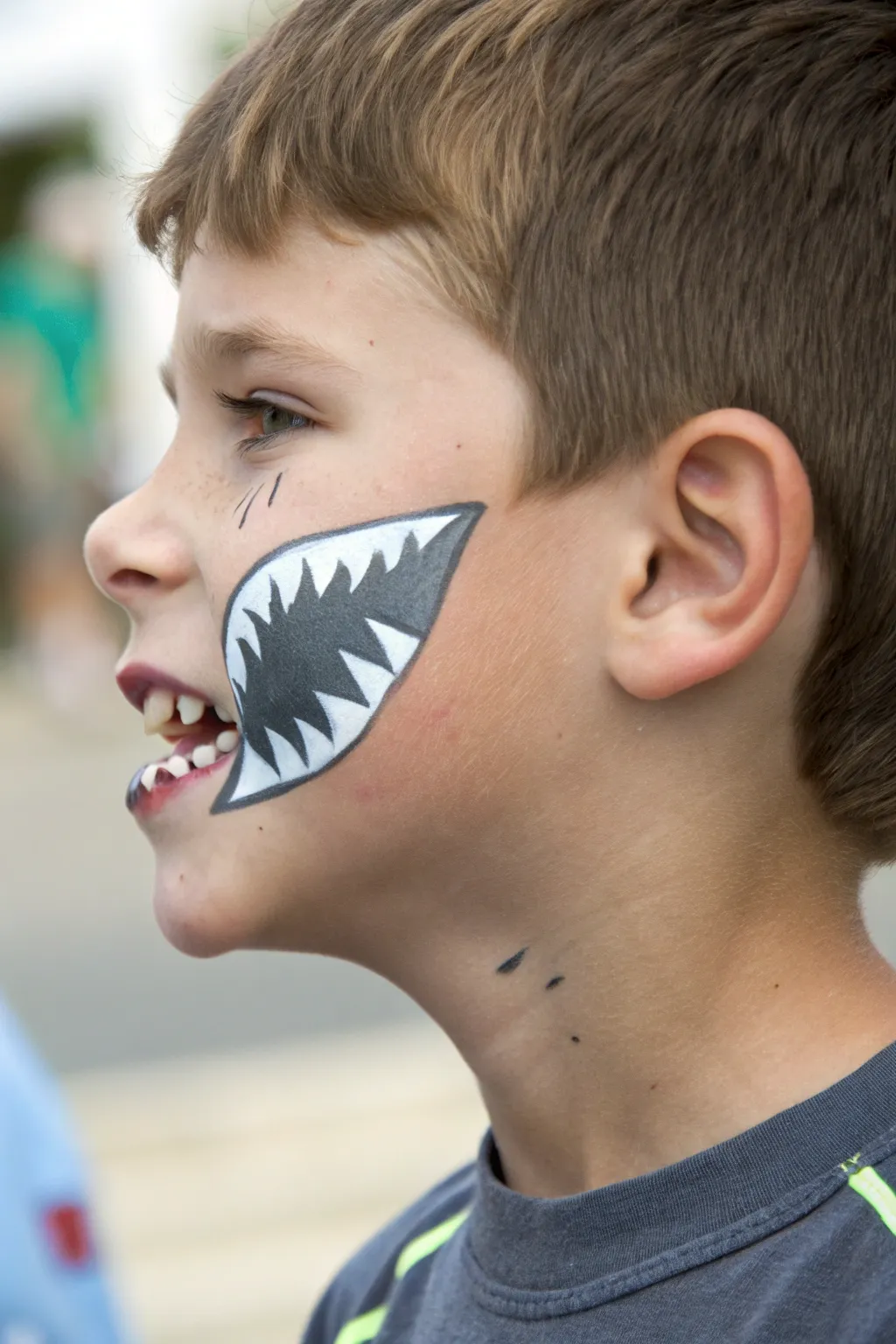 Minimalist shark bite cheek face paint that pops, perfect for boys parties and play.