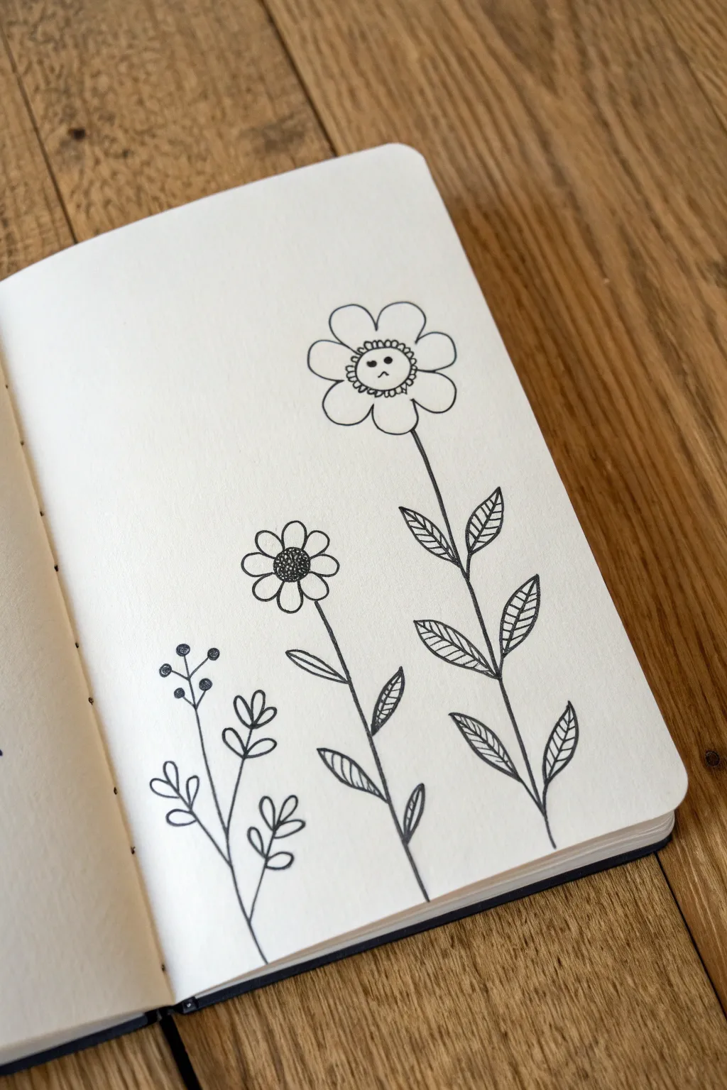 Five-petal flower doodles for your sketchbook, with one sweet little face for extra charm.