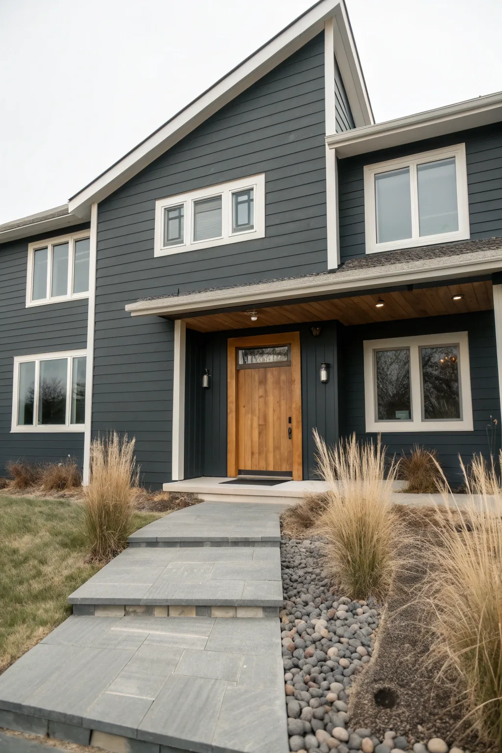 Charcoal siding with creamy trim creates calm contrast for a modern, minimalist exterior.