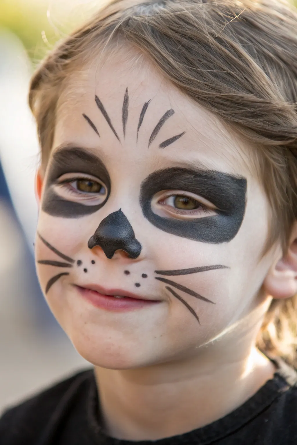 Minimal black cat face paint with bold nose, fine whiskers, and soft liner for quick Halloween fun