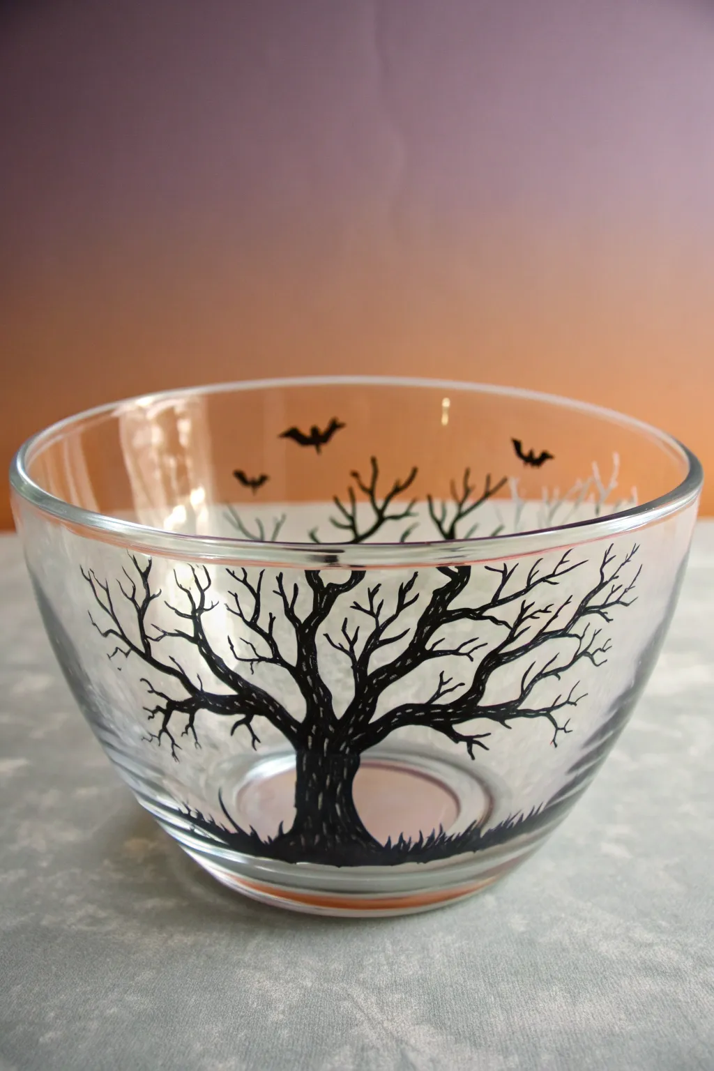 Haunted tree silhouette on glass with dusky sunset wash, a chic minimalist Halloween vibe.
