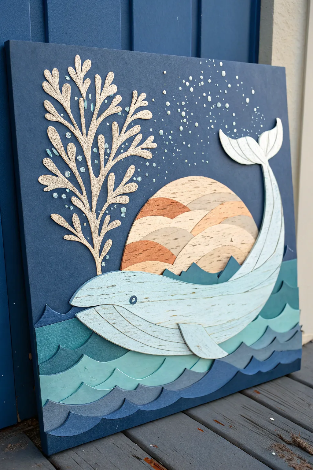 Layered paper whale with a crisp white spout on deep blue, minimalist boho ocean mood.