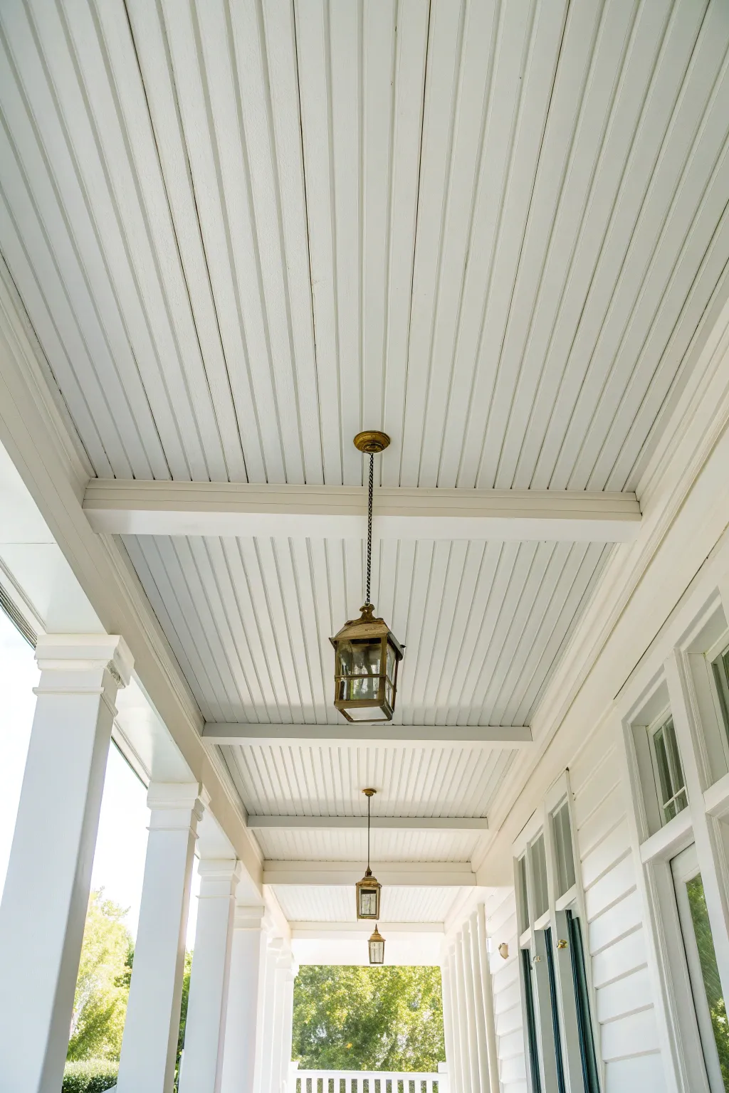 Bright white porch ceiling paint lifts the whole space with an airy, soft glow.