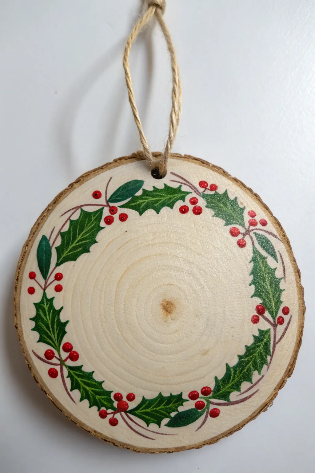 Minimalist painted wood ornament with holly leaves and bright red berries border
