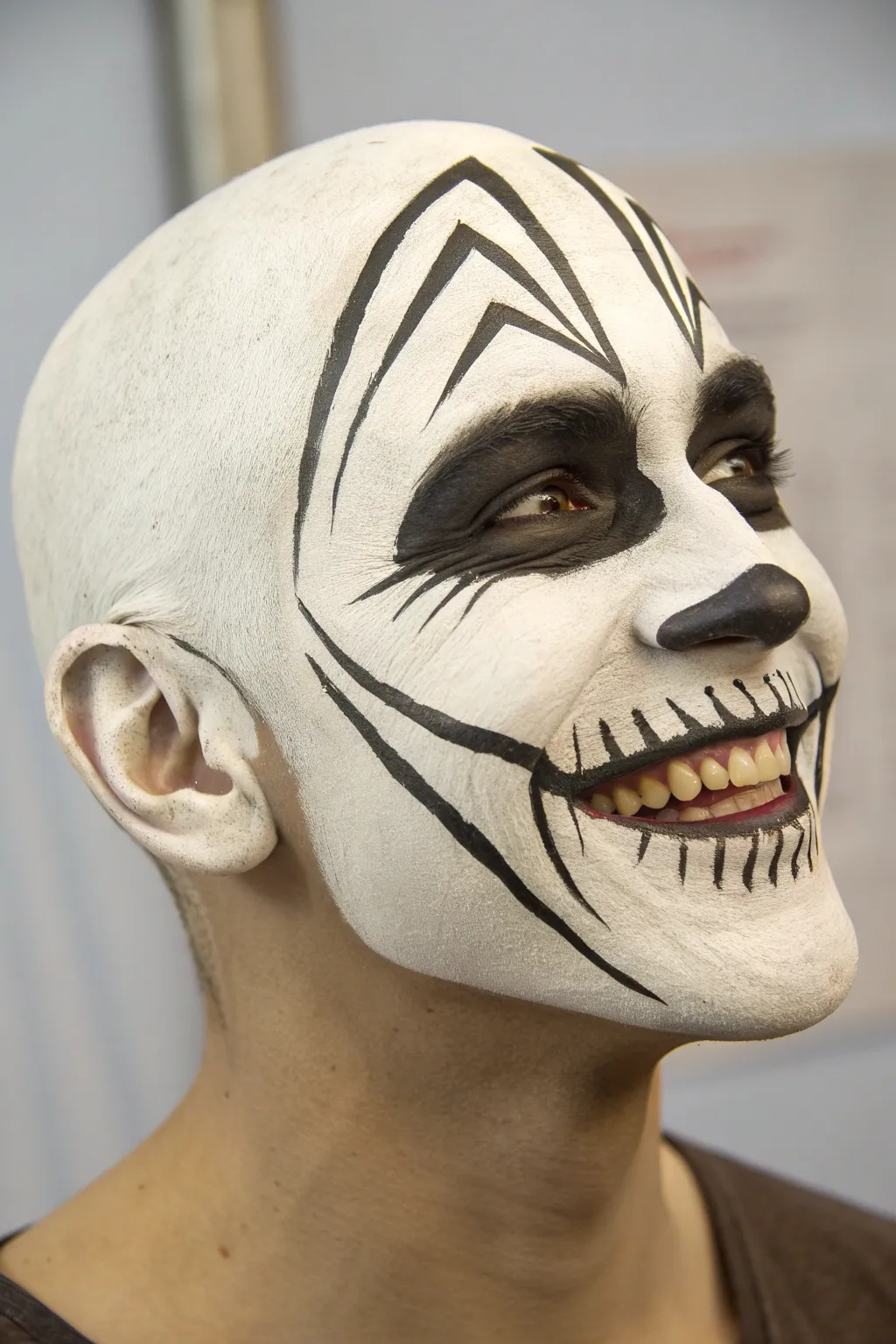 Clean minimalist skull face paint with a teeth-forward grin, crisp lines and soft natural shadows.
