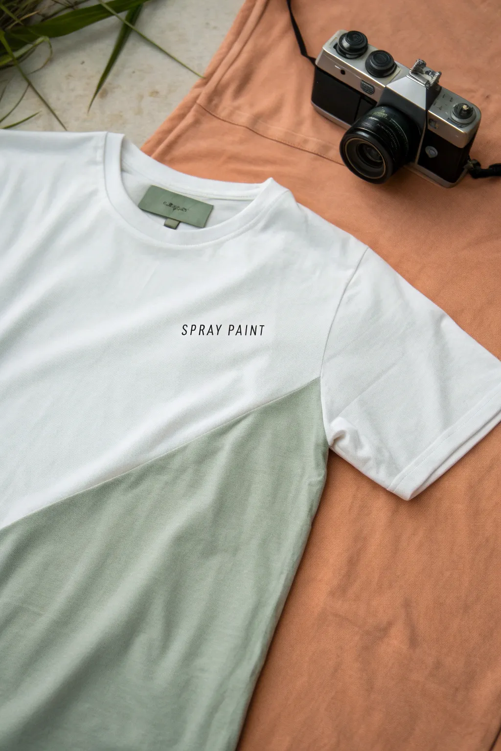 Clean diagonal two-tone spray tee with crisp masking and minimal name detail, Scandinavian boho vibe.