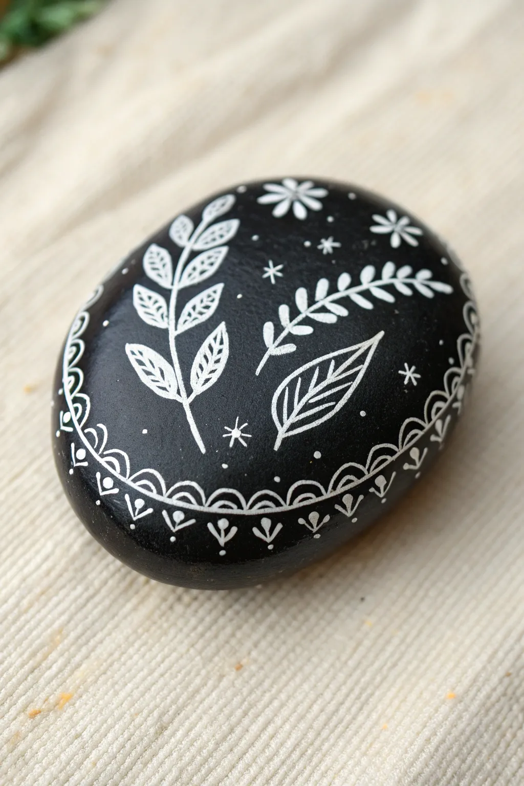 Minimal black rock with delicate white doodle border, Scandinavian boho contrast for easy inspo.