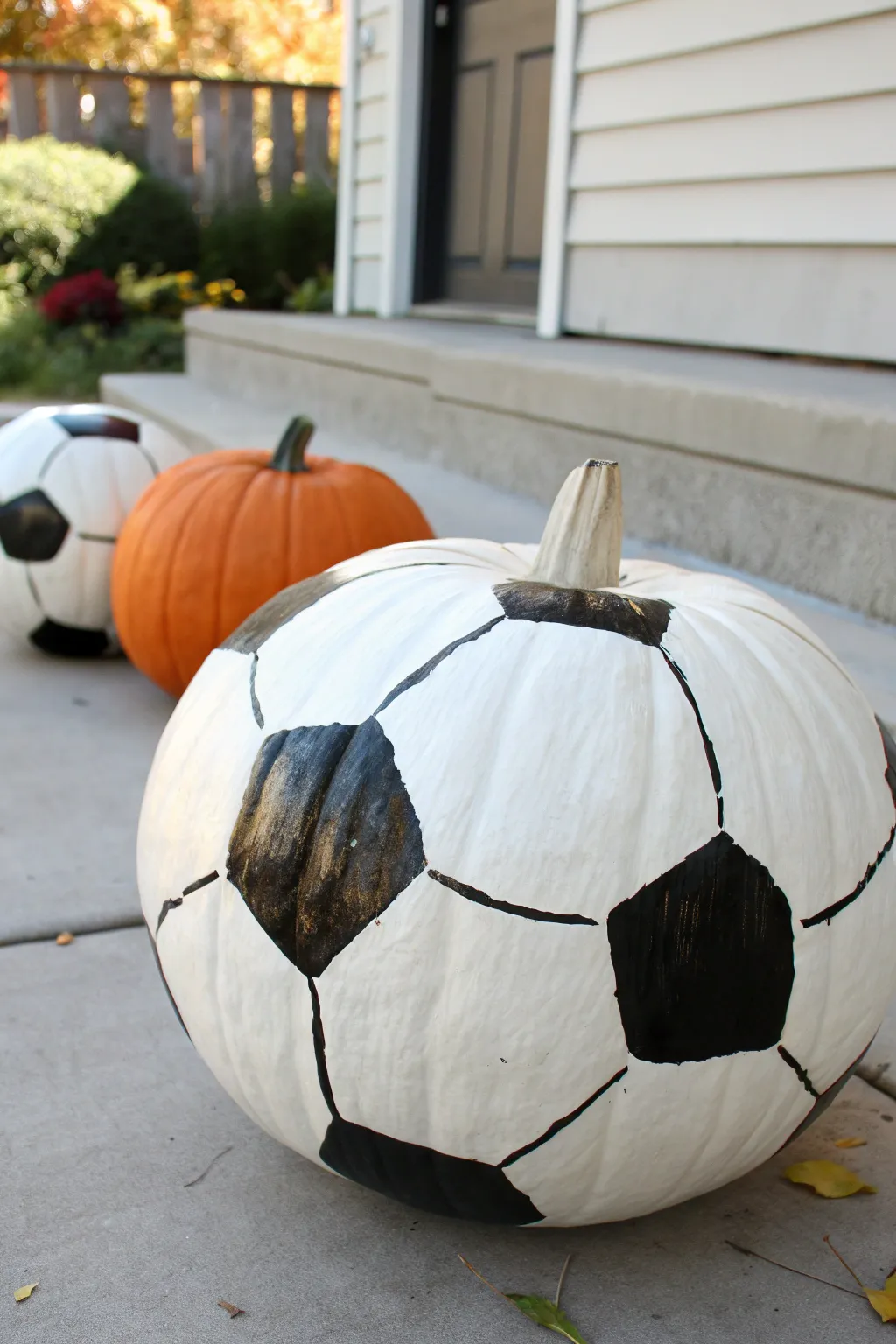 Sporty pumpkin face-off: a hand painted soccer ball pumpkin with a rival in the background