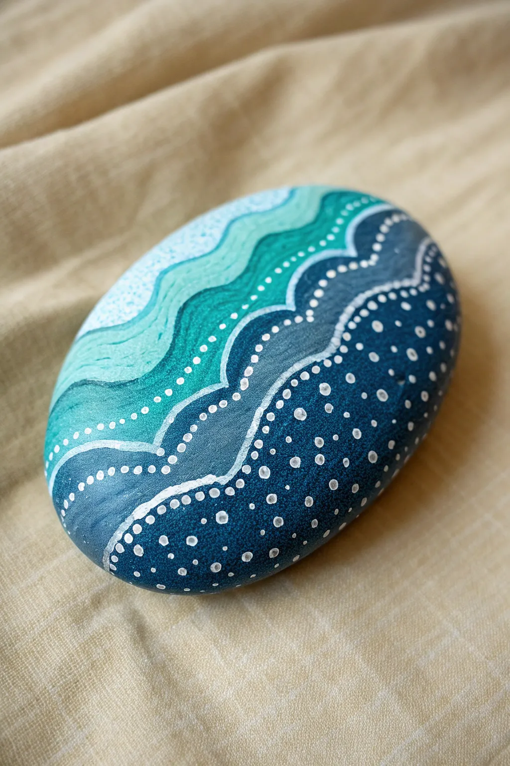 Ocean wave dot lines on a smooth stone, minimalist boho palette for calm seaside vibes.