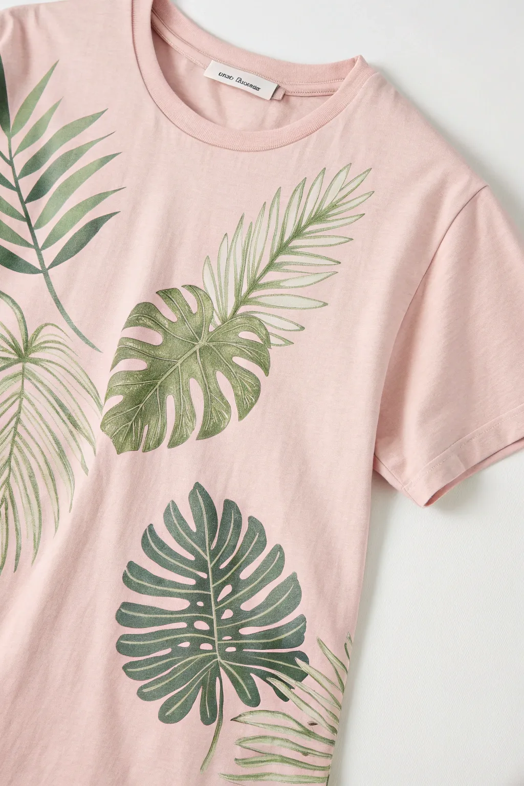 Fresh summer tee with layered tropical leaves in bright greens, minimal Scandinavian-boho vibe