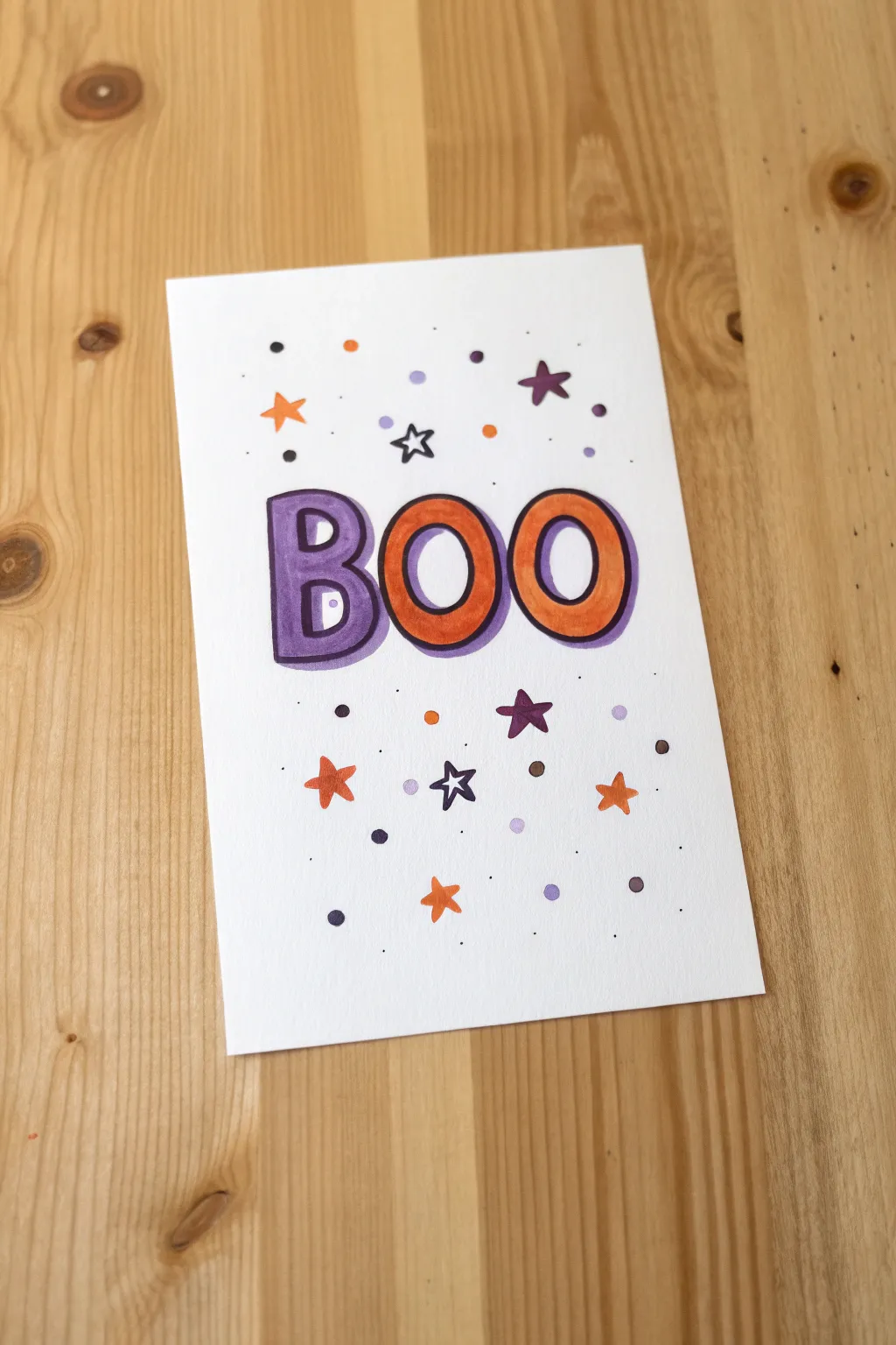Bold orange and purple bubble BOO with crisp black outline and confetti dots for easy kid art