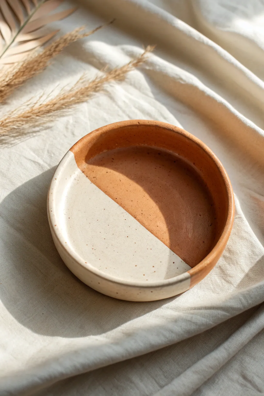 Half-dipped jewelry dish in muted terracotta with a crisp line, minimalist Scandinavian boho style.