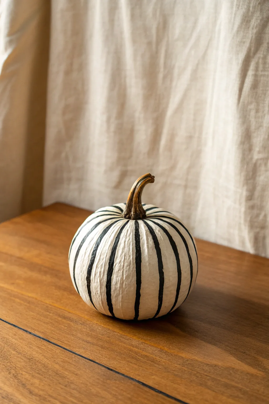 Minimal striped mini pumpkin with crisp groove-following lines and warm Scandinavian contrast