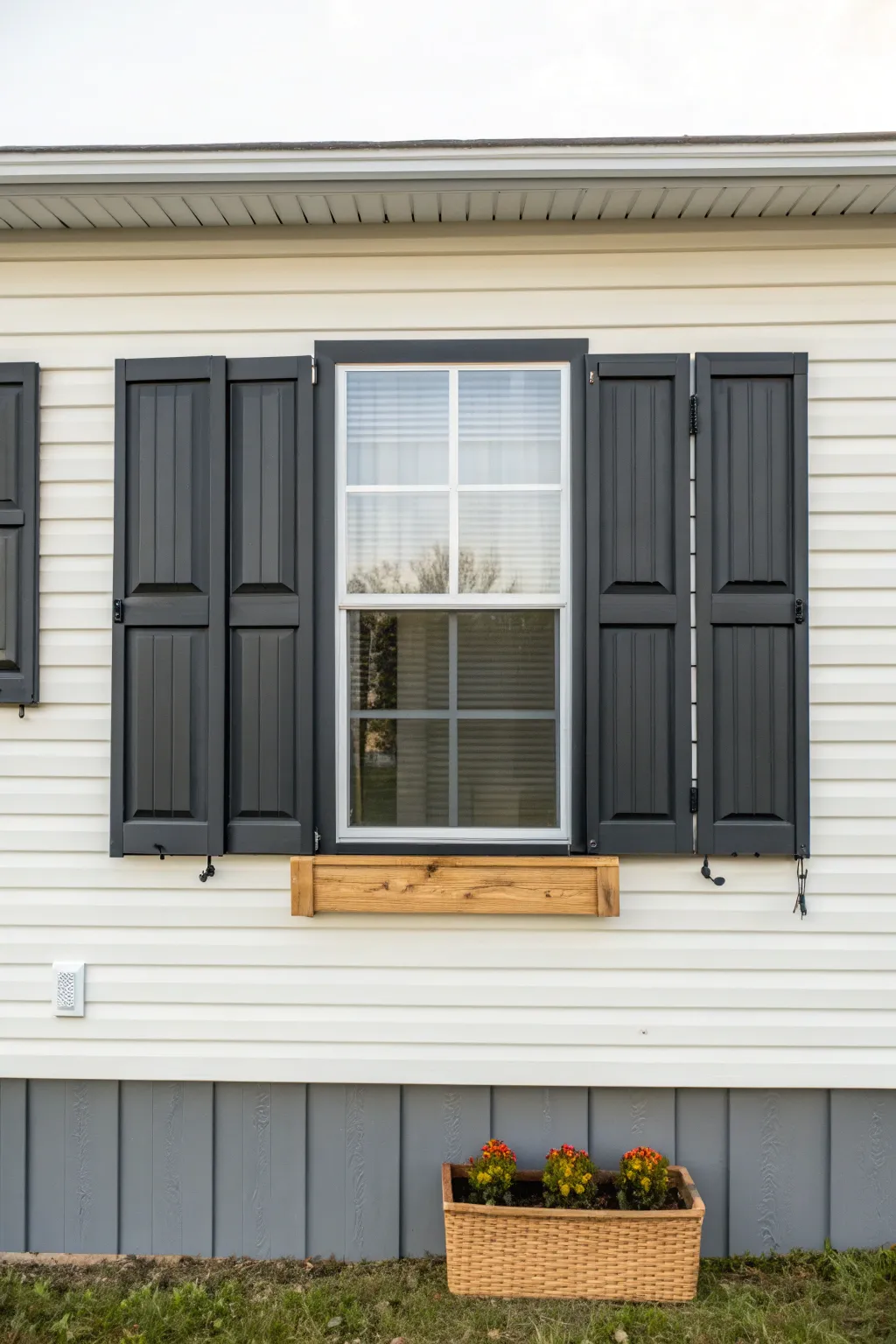 Dark matte shutters on pale siding add instant structure and style to a mobile home exterior.