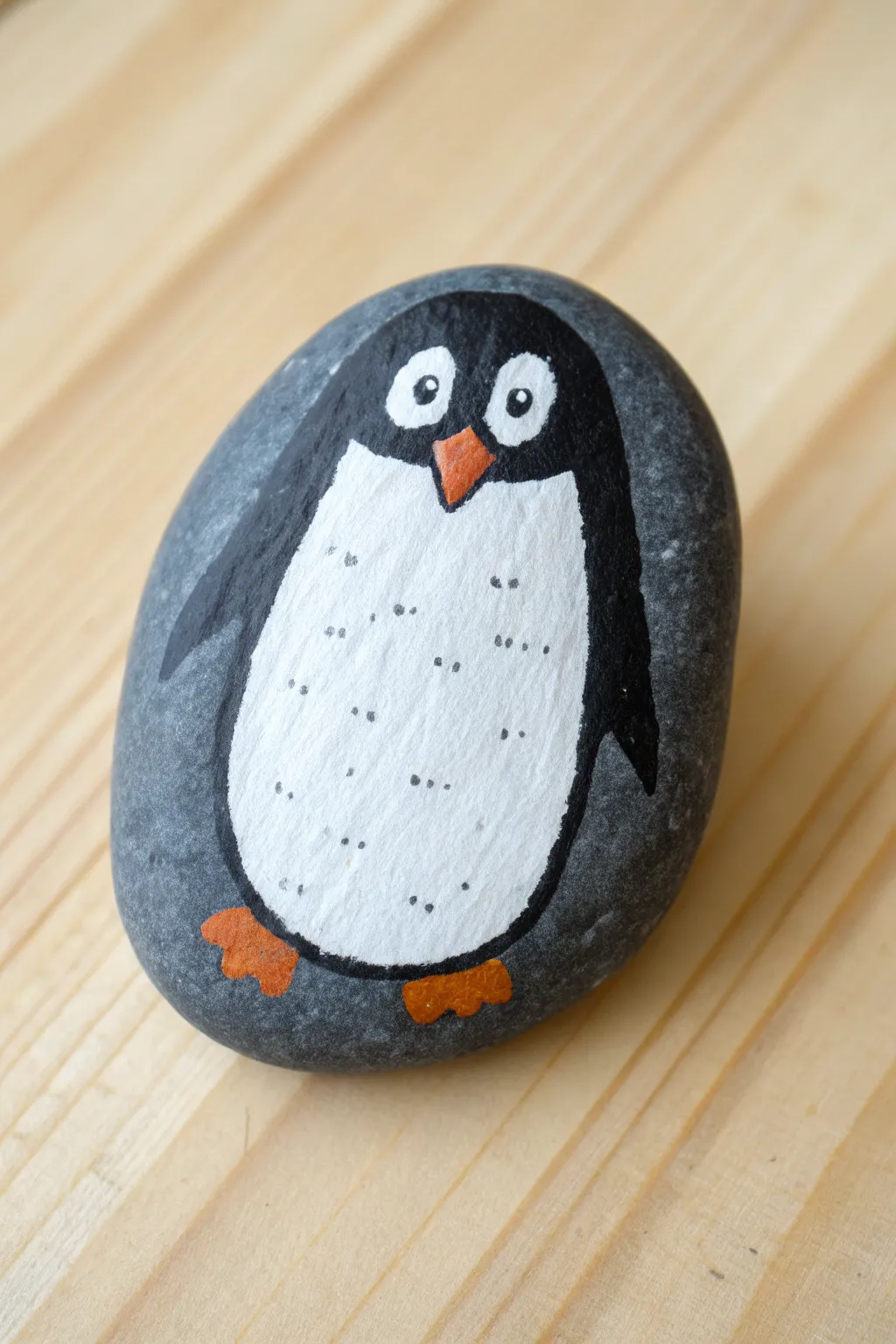 Oval rock penguin idea: upright body shape, simple white belly, and tiny orange details