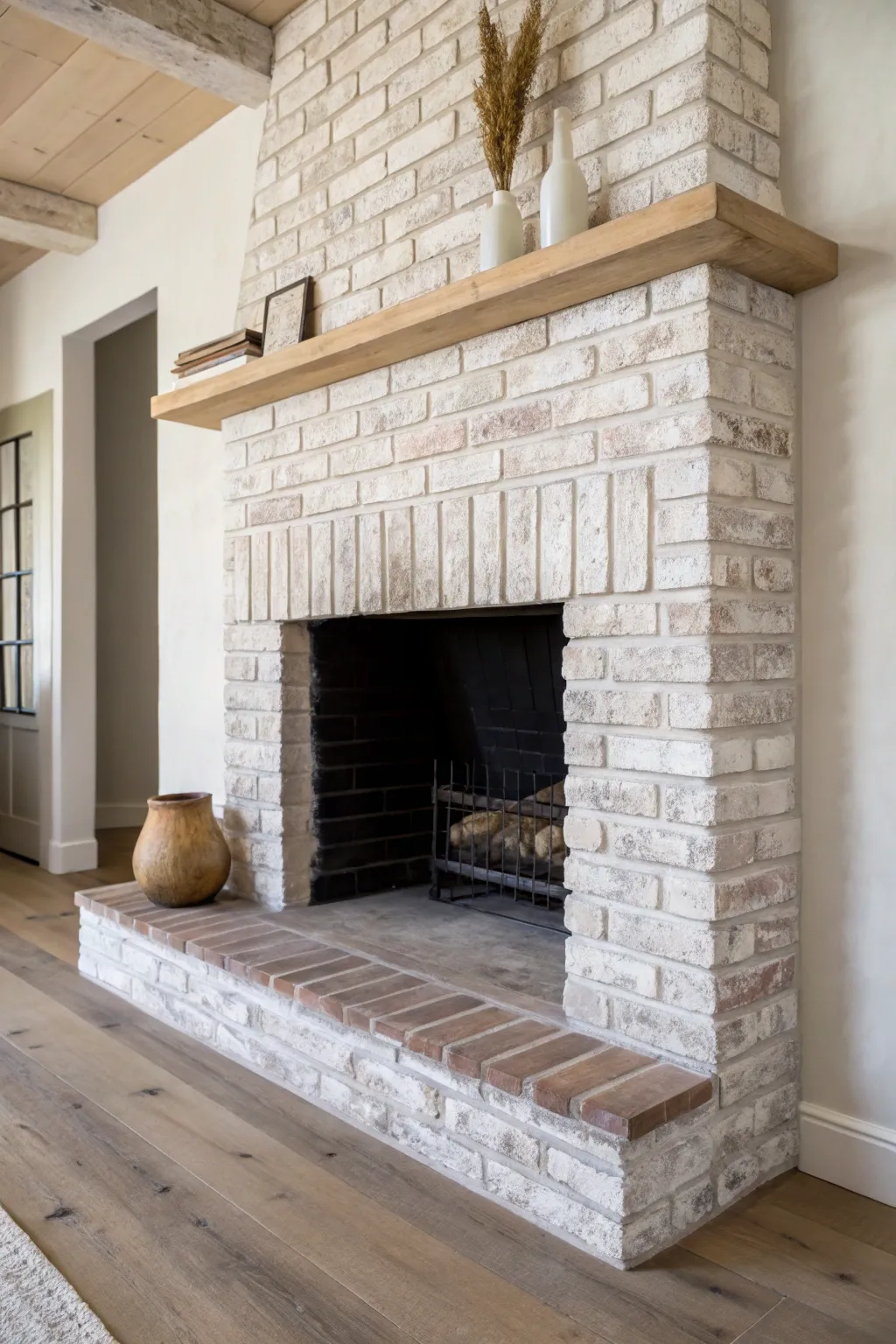 Chalky mineral wash transforms old brick into a soft, old-world fireplace centerpiece.