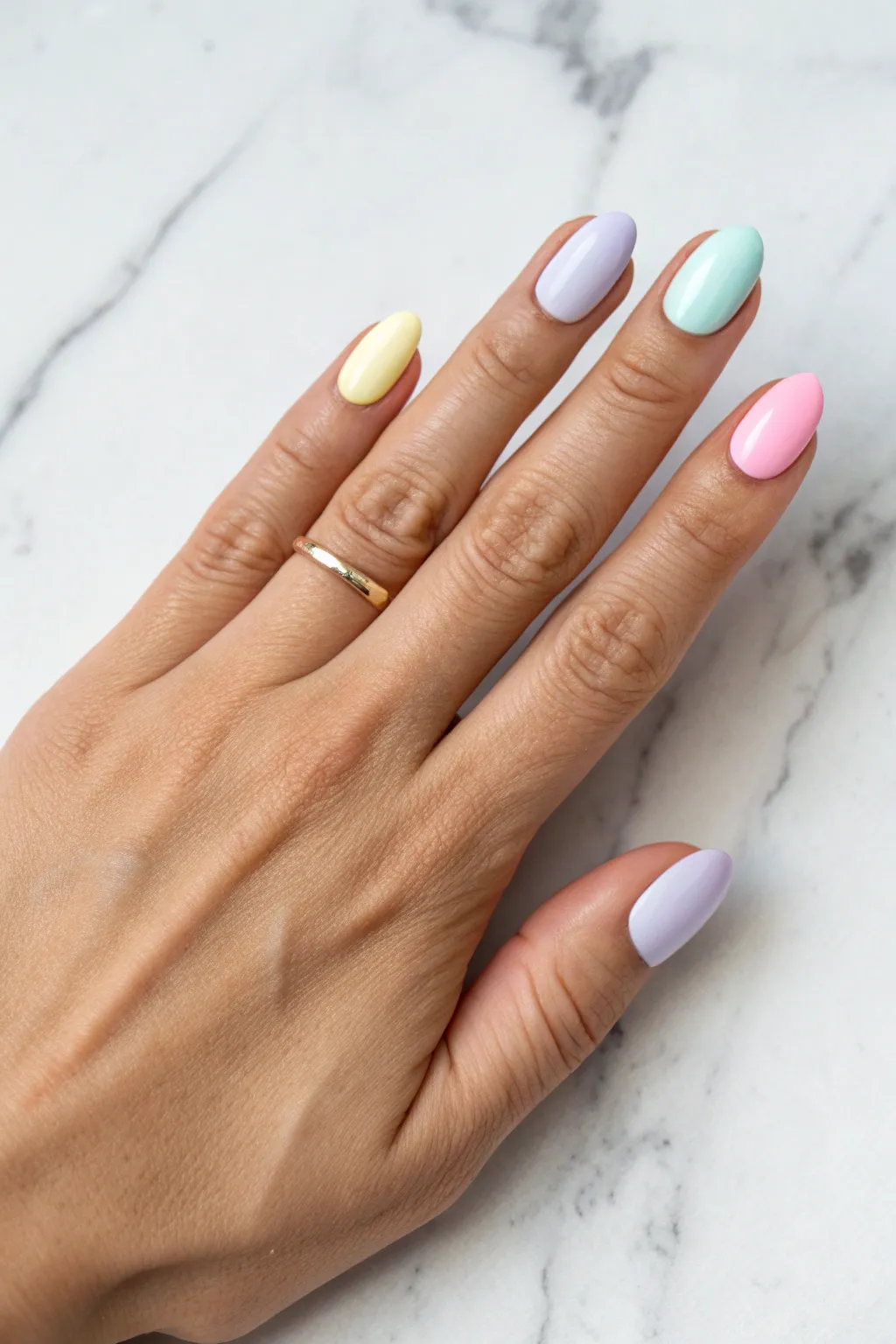 Soft rainbow pastel skittle manicure on a clean hand pose, minimalist Scandinavian mood.