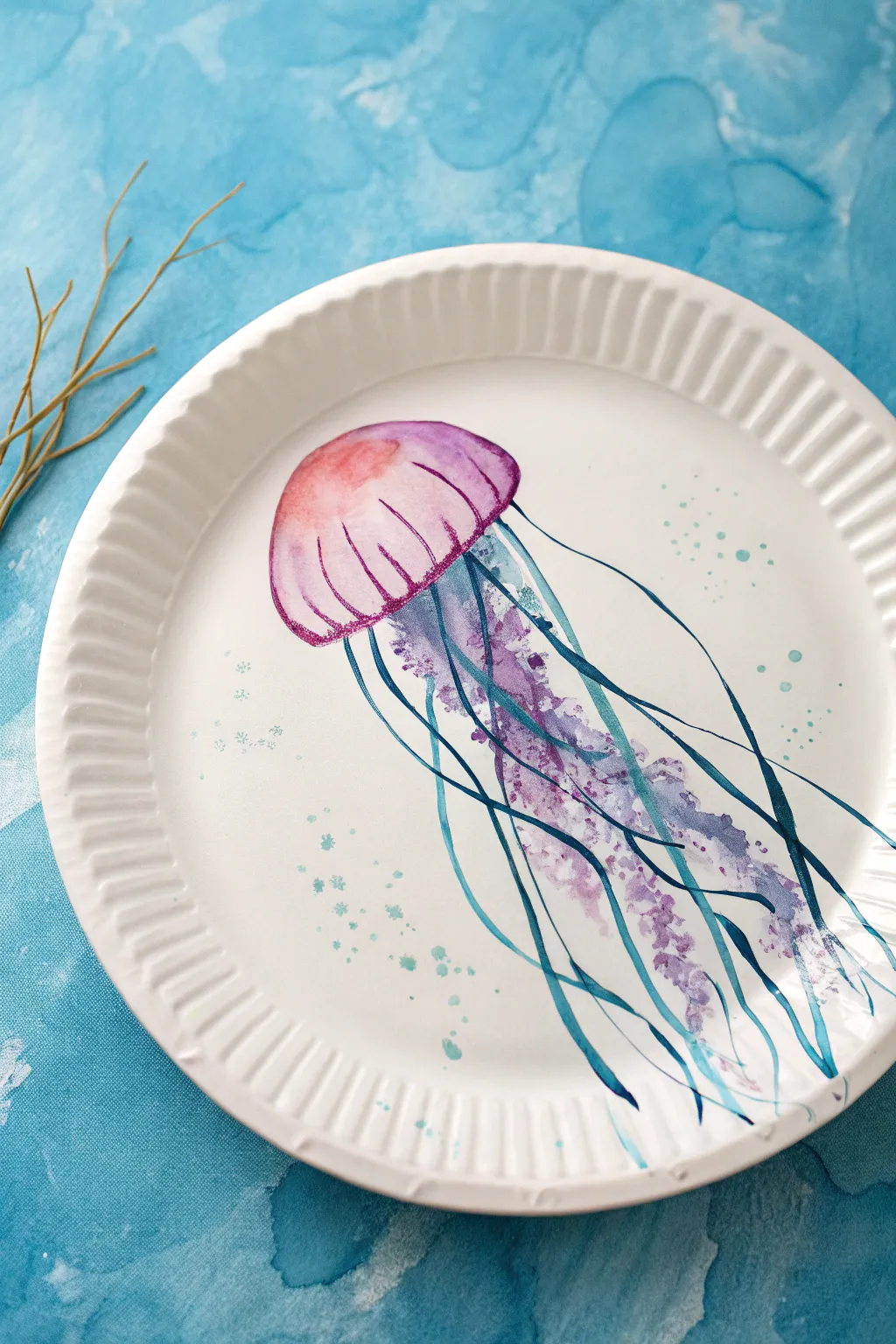 Simple jellyfish drip-painted paper plate craft in calm ocean blues, minimalist and dreamy.
