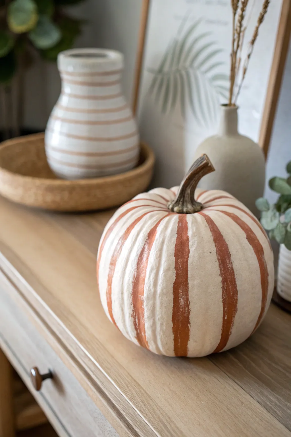 Minimalist pumpkin with curved monochrome stripes, styled in cozy Scandinavian boho neutrals