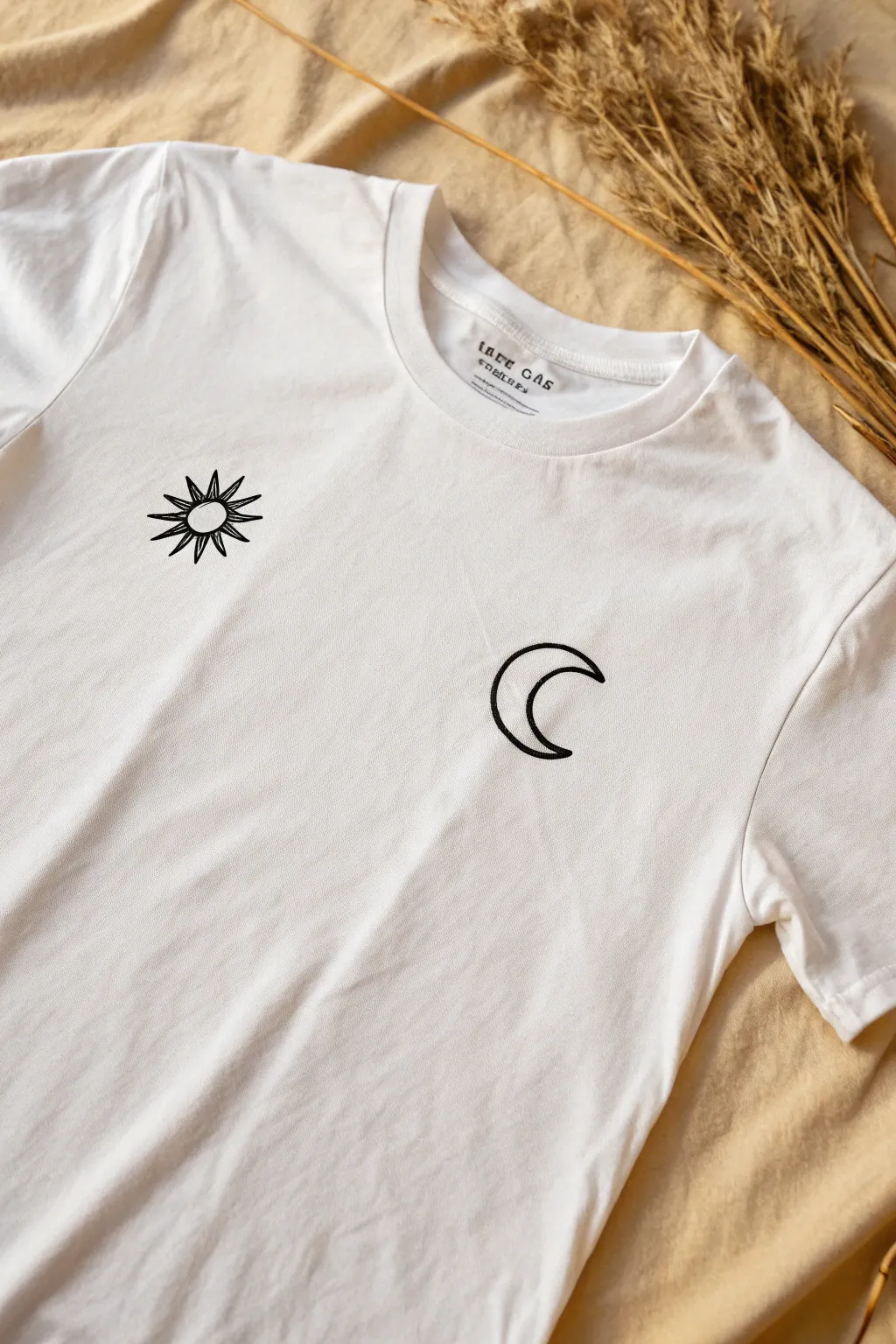 Minimal sun and crescent moon outlines show an easy balanced chest-print T-shirt idea