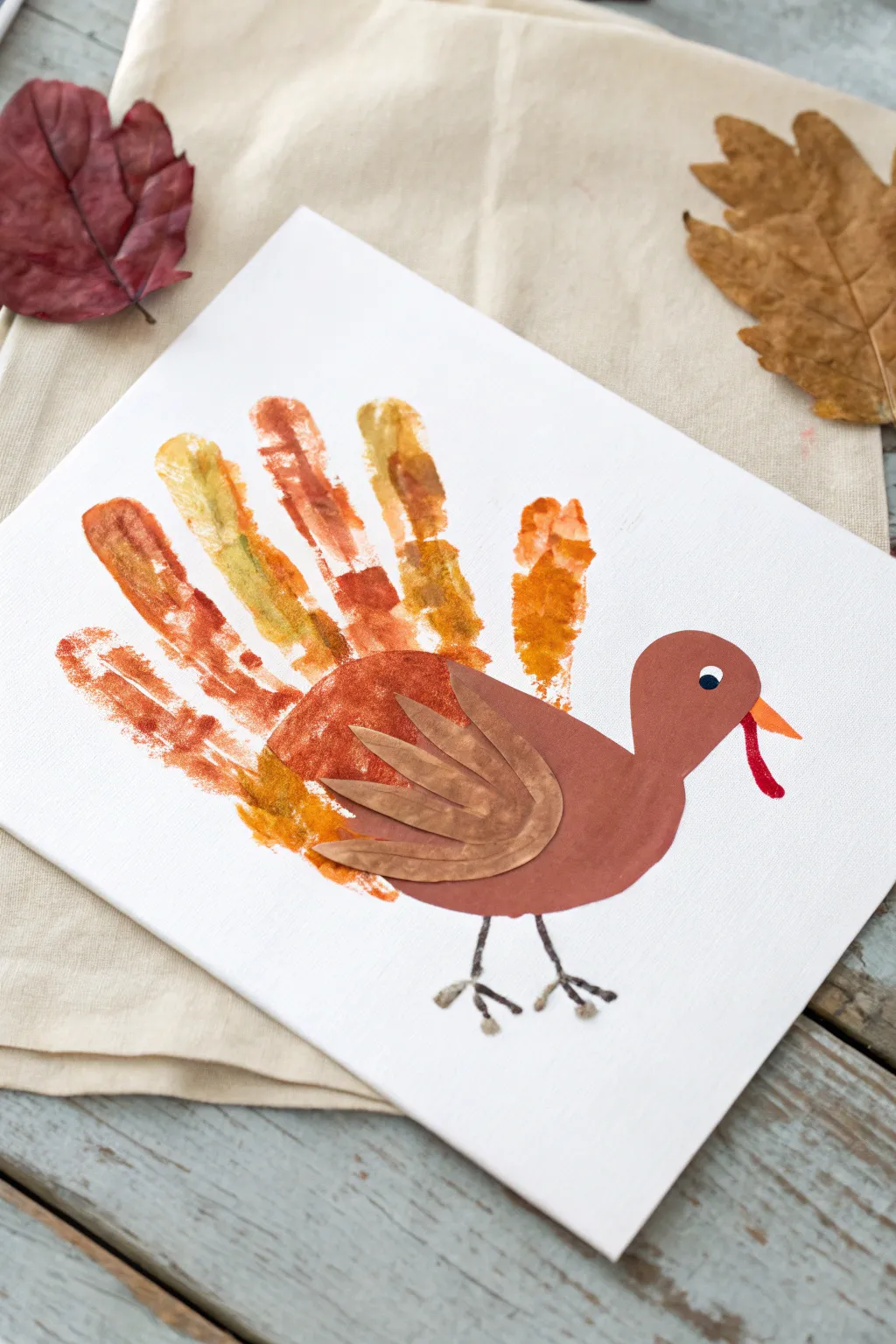Minimal handprint turkey keepsake on white paper, earthy tones, soft light, clean Nordic table.