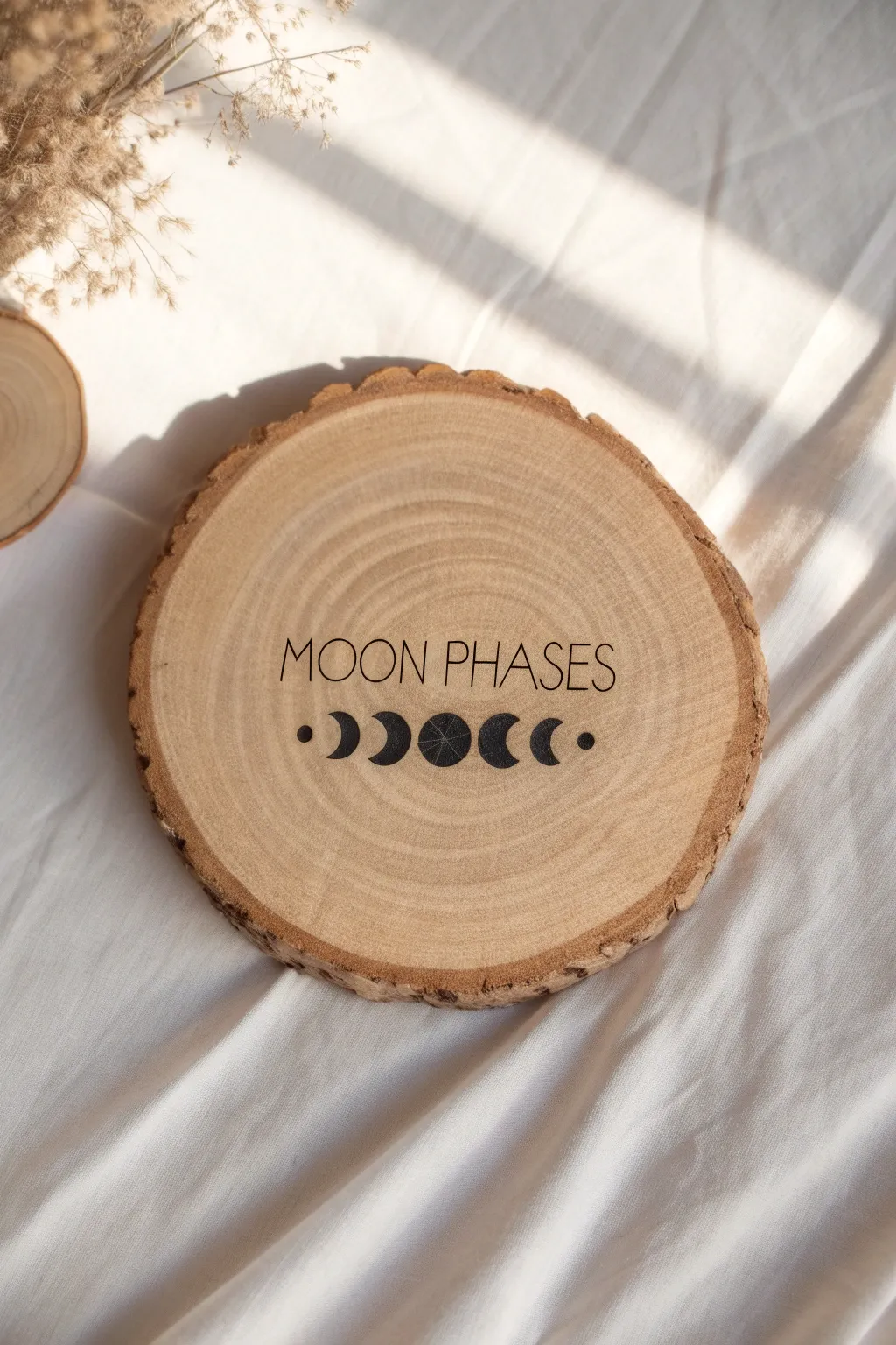 Minimal moon phases on a wood slice, letting the natural grain frame each lunar shape.