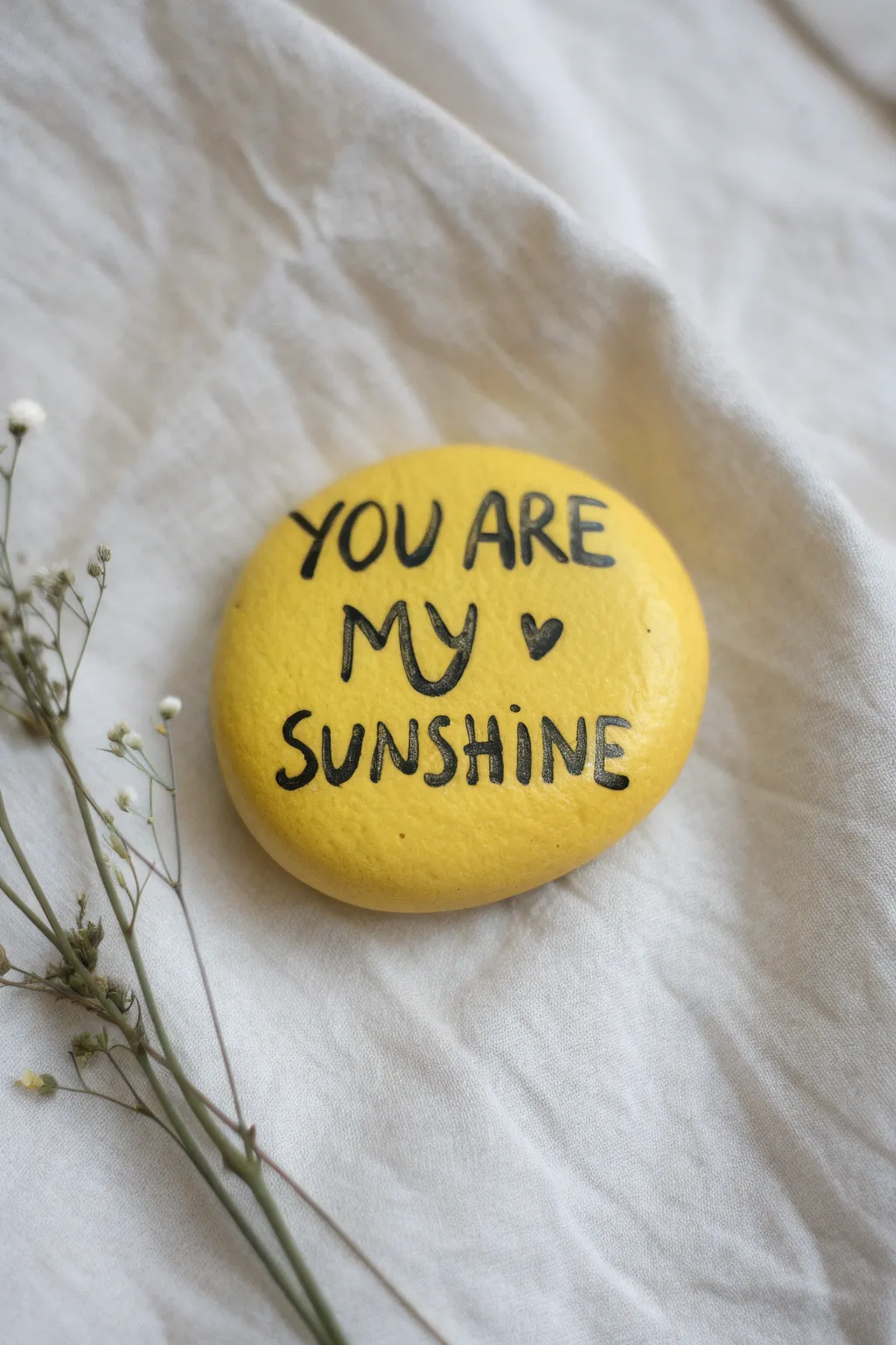 Easy yellow rock painting with You Are My Sunshine lettering for a bright, minimalist vibe